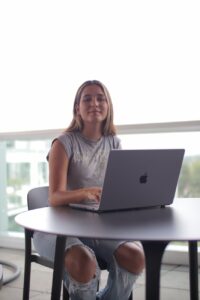 a woman sitting at a table with a laptop